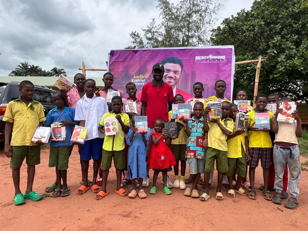 Children holding school supplies during a community outreach