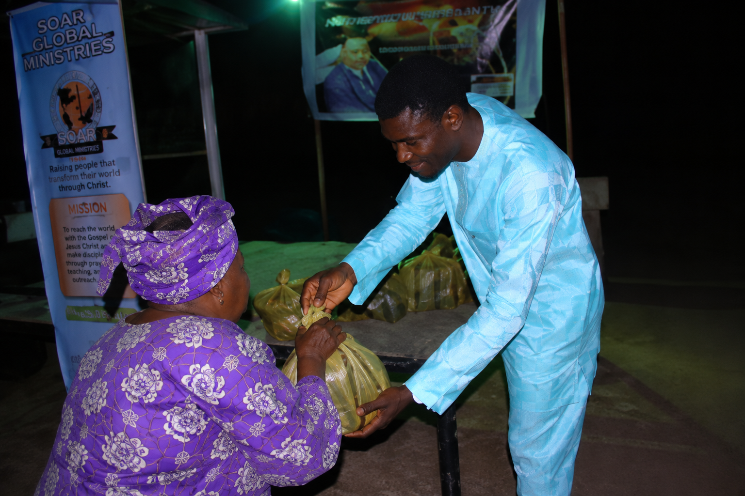 A local partner giving food support to a woman during outreach